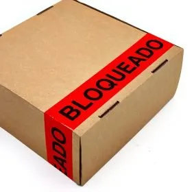 Caja de cartón a la que se le ha aplicado la cinta adhesiva de color naranja - rojo con el texto de BLOQUEADO.